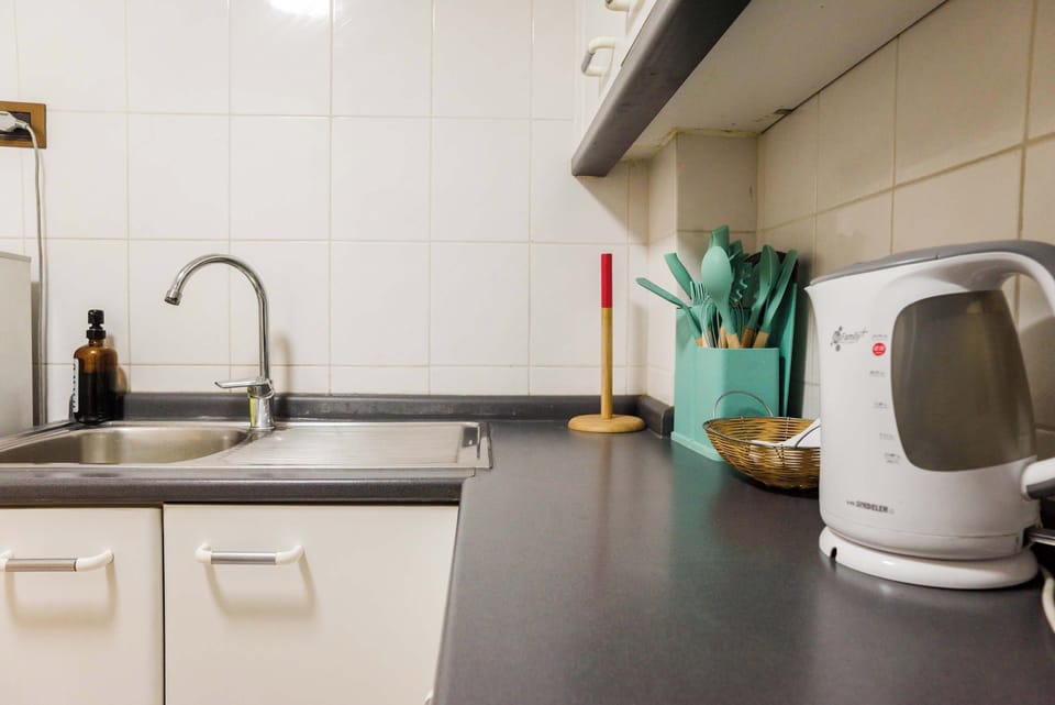 Enjoy your coffee or tea with the provided electric kettle. The kitchen is fully equipped with a modern faucet and attractive utensil storage for a welcoming touch.