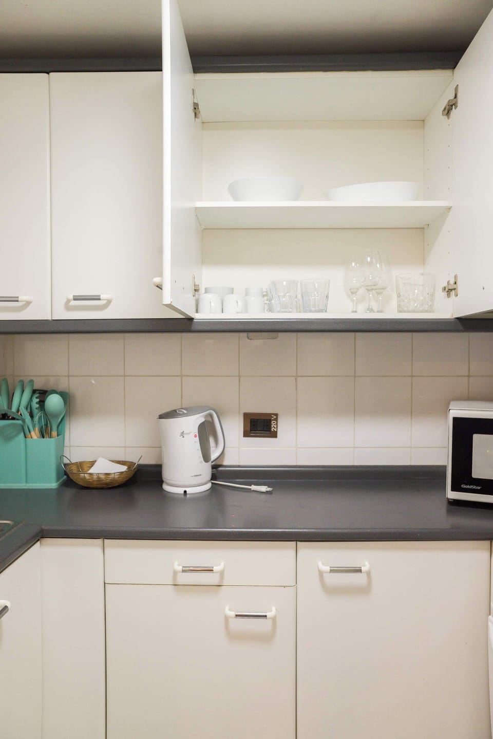 Everything you need for dining is ready! The kitchen is fully stocked with plates, bowls, and glasses neatly organized in the accessible upper cabinets.