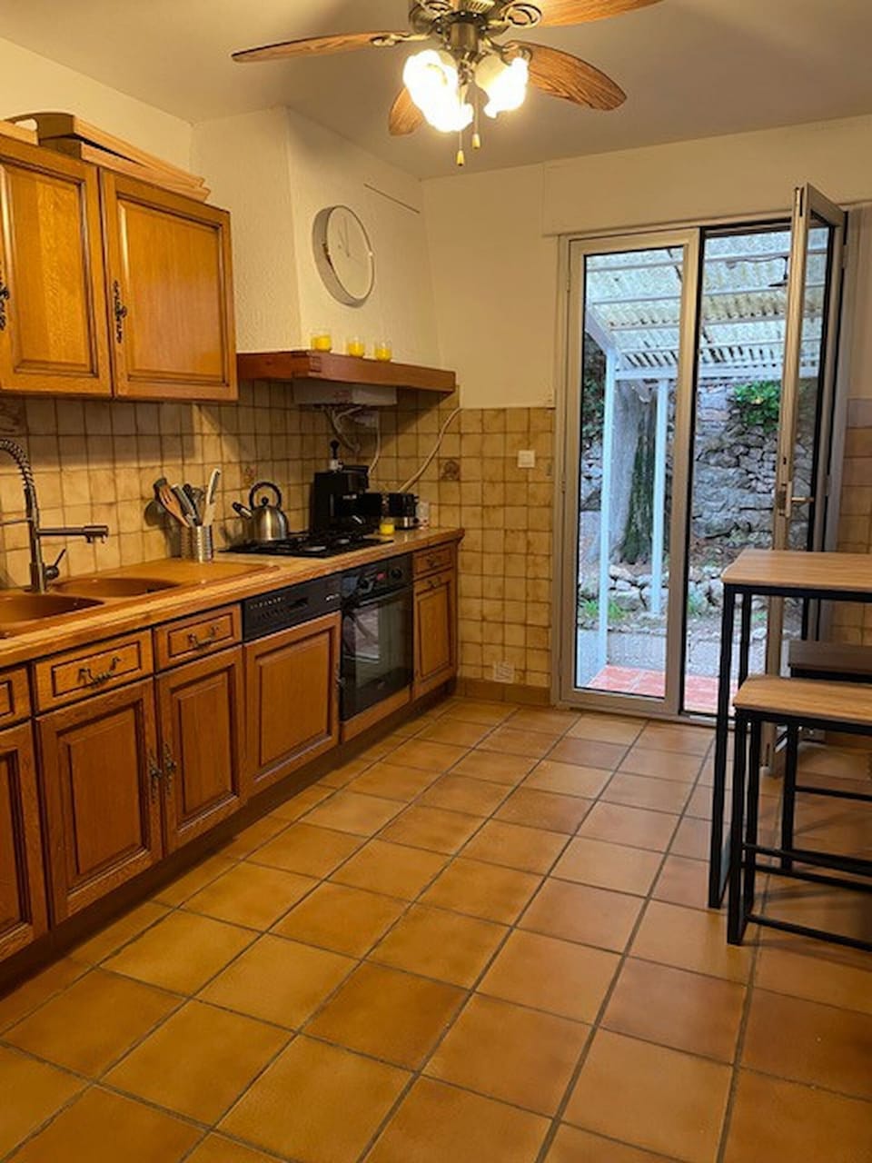 The kitchen overlooks the sheltered terrace with the outdoor dining area