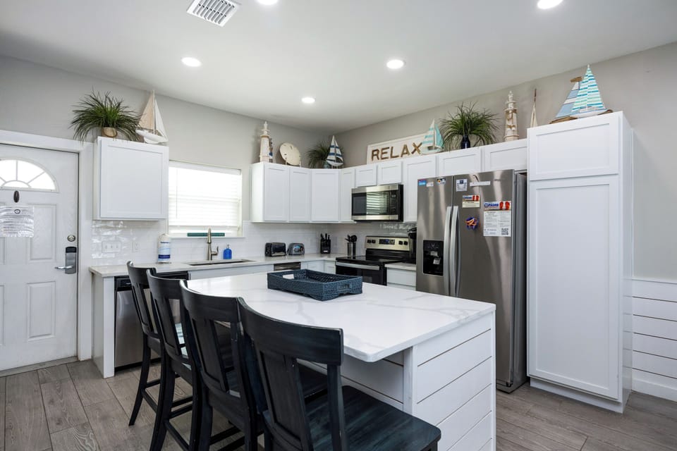 Your spacious beach-themed kitchen invites culinary adventures with modern appliances, marble countertops, and coastal charm throughout.