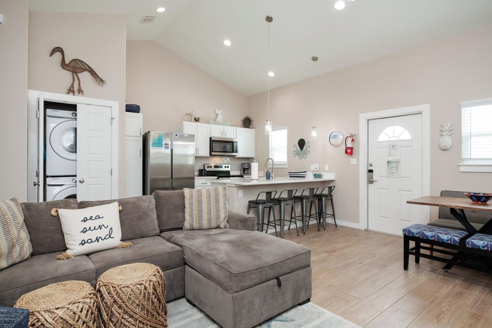 Relax in your bright, modern living space with a plush sectional sofa, fully equipped kitchen, and coastal touches that make you feel right at home.