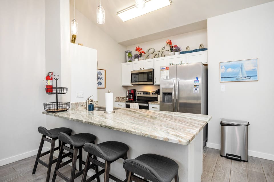 Cook your favorite meals in your fully-equipped kitchen, featuring granite countertops and modern appliances.