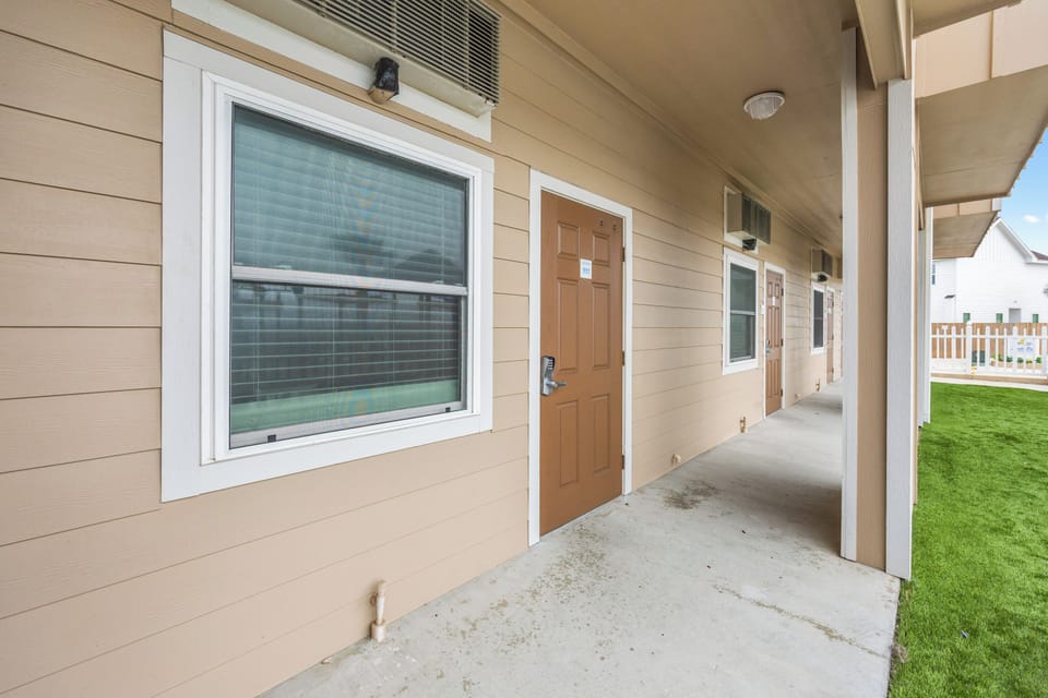 Modern building exterior with covered walkway and clean architectural lines in a quiet residential setting.