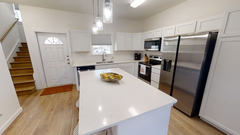 Your fully equipped kitchen features gleaming quartz countertops, stainless steel appliances, and elegant pendant lighting for memorable meal preparation.