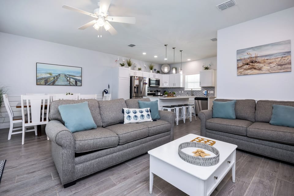 Sink into these plush sofas and let the coastal vibes wash over you in this bright, airy living space with modern comforts.