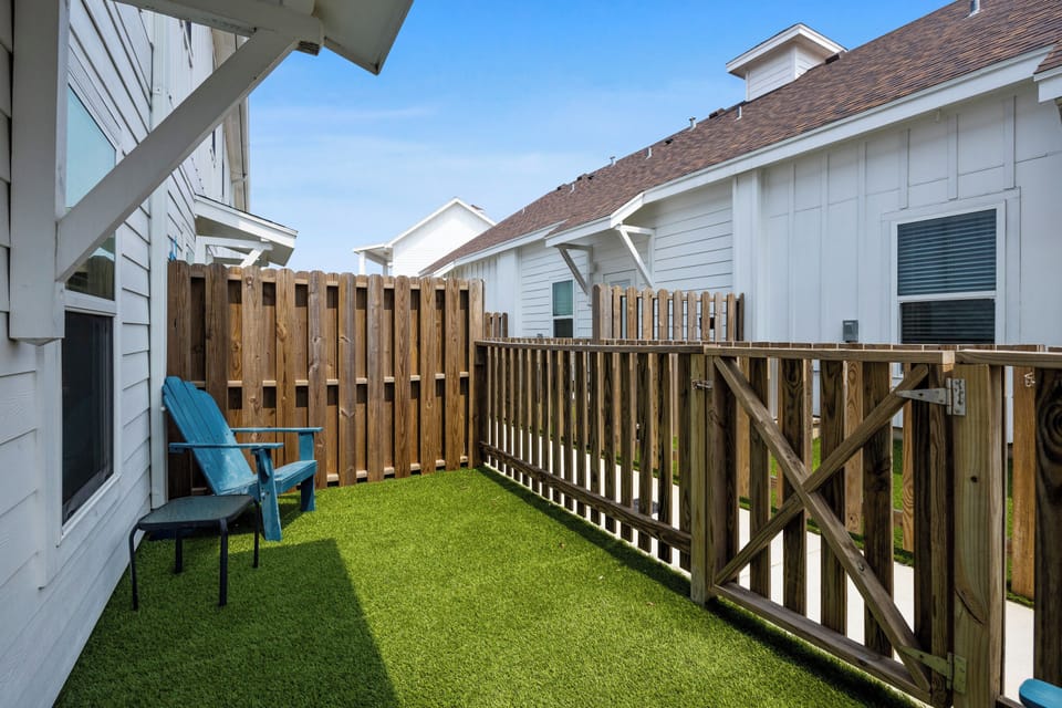 Your private fenced patio offers the perfect spot to relax on the turquoise chair while enjoying the sunshine.