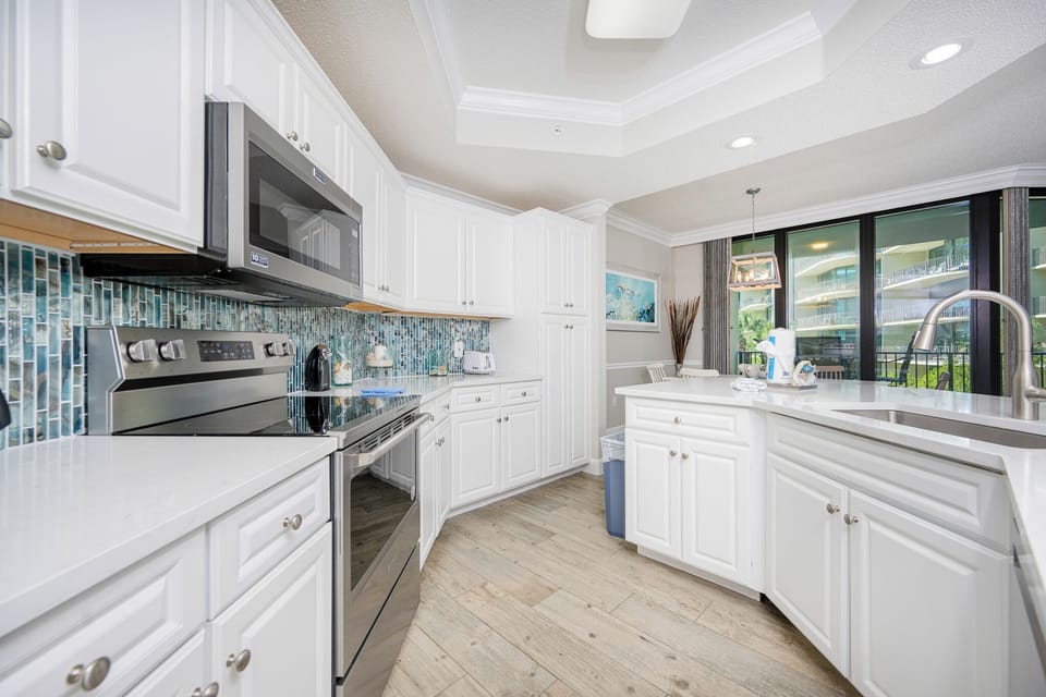 Prepare meals in this kitchen with elegant cabinetry, stainless appliances, and stylish backsplash