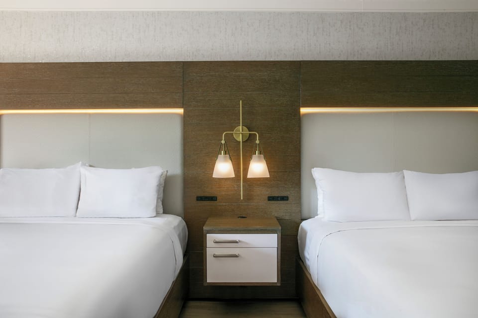 Drift off in crisp linens with warm bedside lighting.