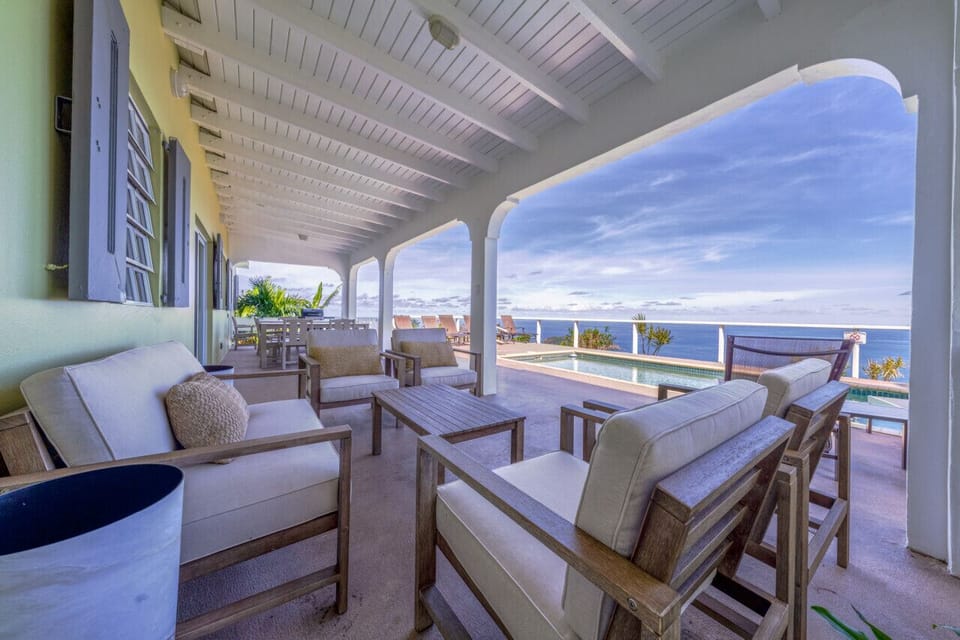 The partially covered pool deck with wifi, outdoor furniture, sun loungers, & BBQ grill - all with an incredible view!