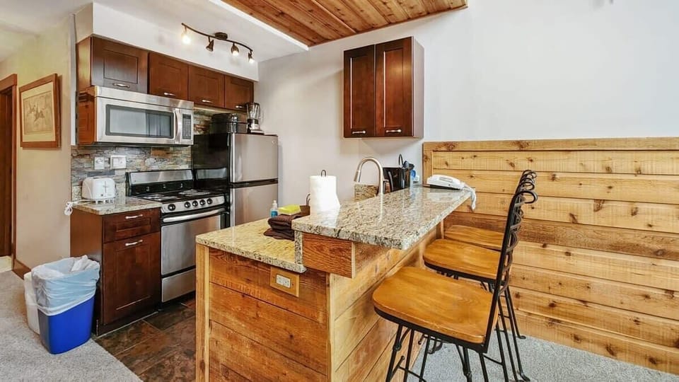 The fully-equipped kitchen features lovely granite countertops, stainless steel appliances, a range of cookware, and a kitchen bar with seating for 3.
