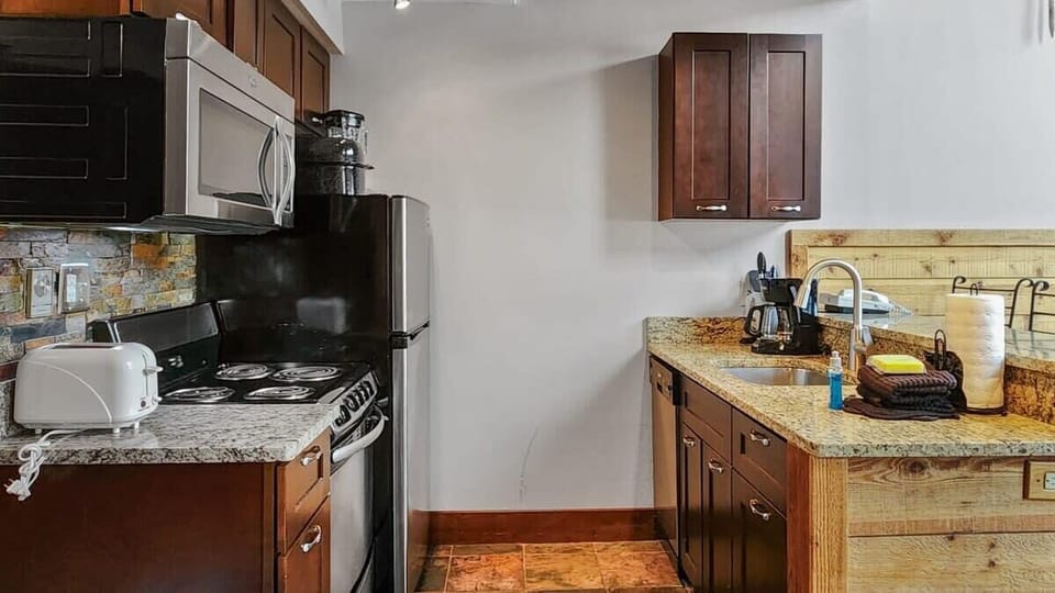 The fully-equipped kitchen features lovely granite countertops, stainless steel appliances, a range of cookware, and a kitchen bar with seating for 3.