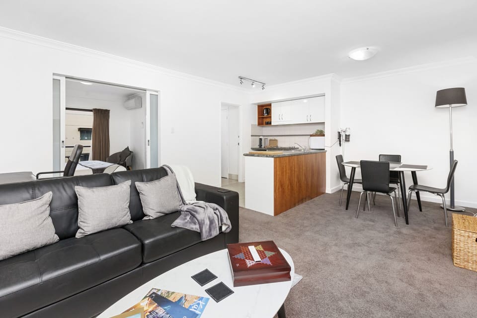 Relax and unwind in this open-plan living space, featuring comfortable seating, a dining area, and a glimpse of the well-equipped kitchen.