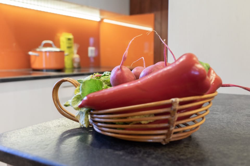 A basket of fresh vegetables on the kitchen worktop