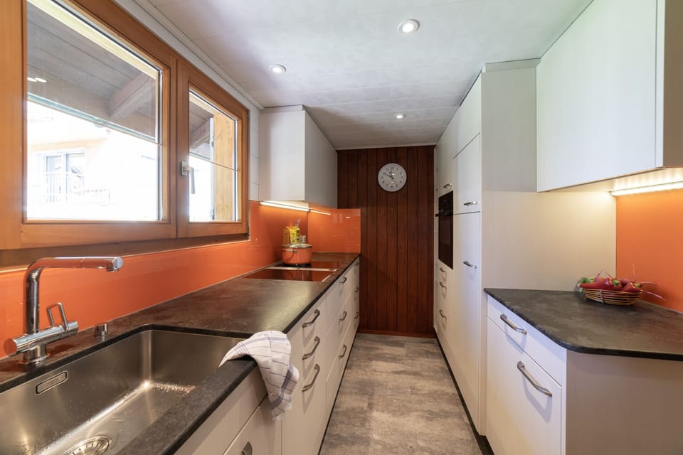 Modern kitchen with a sink, plenty of storage space and a row of windows