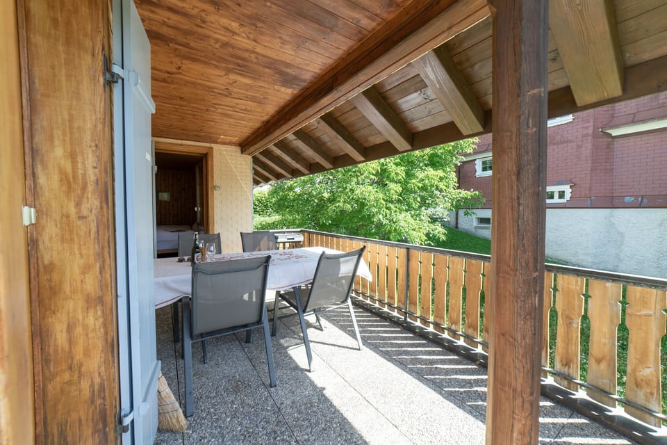 Covered balcony with a dining table and views of the countryside