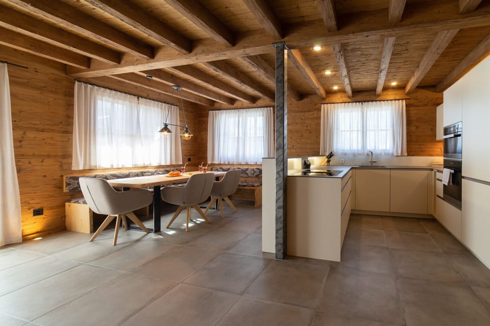Open chalet kitchen with dining area and wooden beams