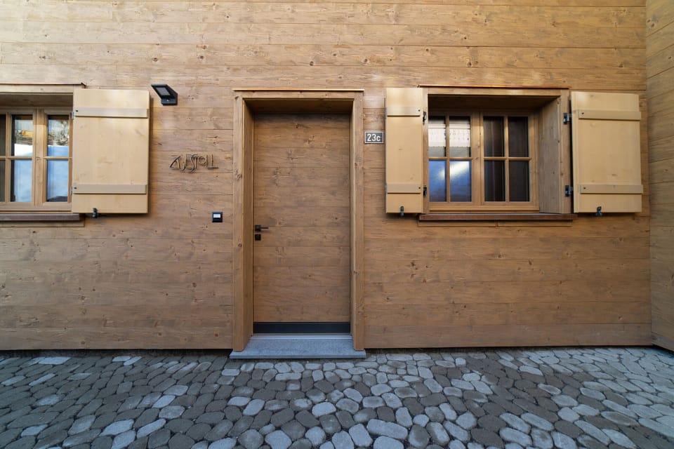 Wooden chalet entrance with traditional window shutters