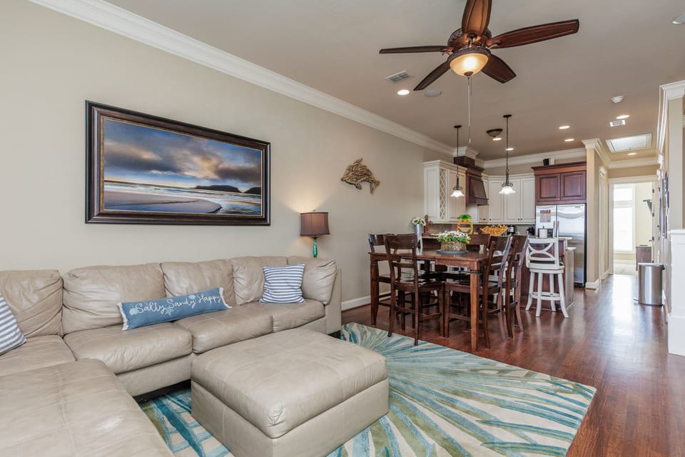Relax in your coastal-themed living space with plush seating and open flow to the kitchen for effortless entertaining.