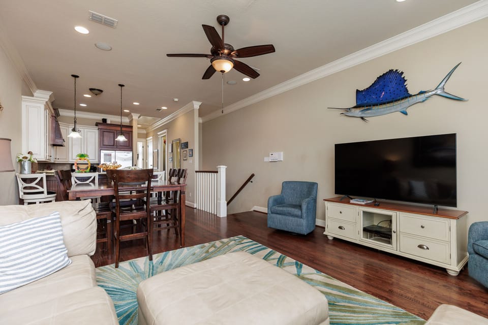 Relax in your spacious living area with coastal décor, where hardwood floors and nautical touches create a welcoming atmosphere for memorable gatherings.