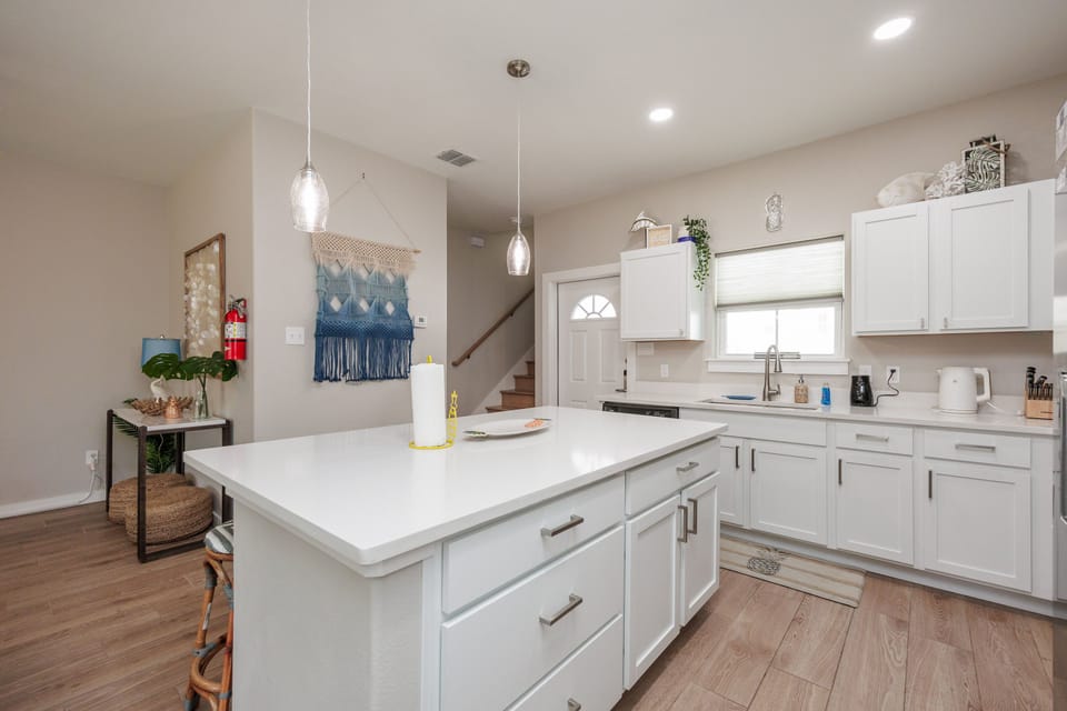 Your modern kitchen features bright white cabinets, a spacious island, and stylish pendant lighting for memorable meal prep.