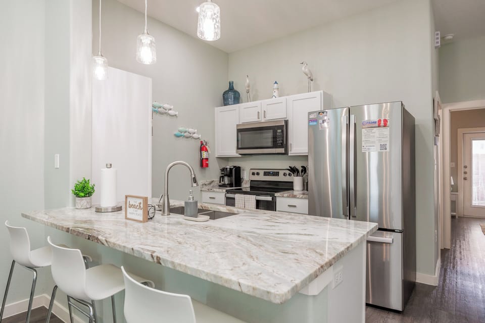 Your fully equipped kitchen features gleaming stainless steel appliances and a stunning marble island where you'll love preparing meals and sharing stories.