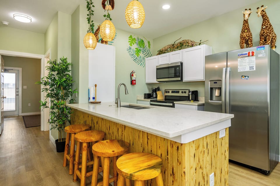 Gather around the stunning kitchen island where tropical vibes meet modern convenience - your cooking adventures await in this safari-themed culinary paradise.