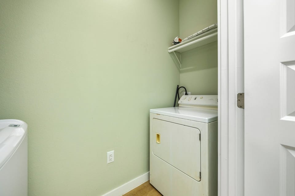 Your dedicated laundry space makes extended stays effortless with full-size washer and dryer in calming green tones.