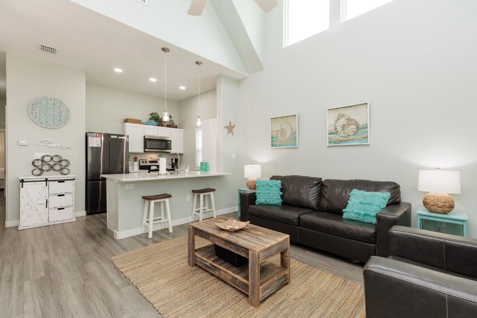 Your bright, open-concept retreat blends comfort with coastal charm. Relax on the cozy sofa while natural light pours through the skylight above.