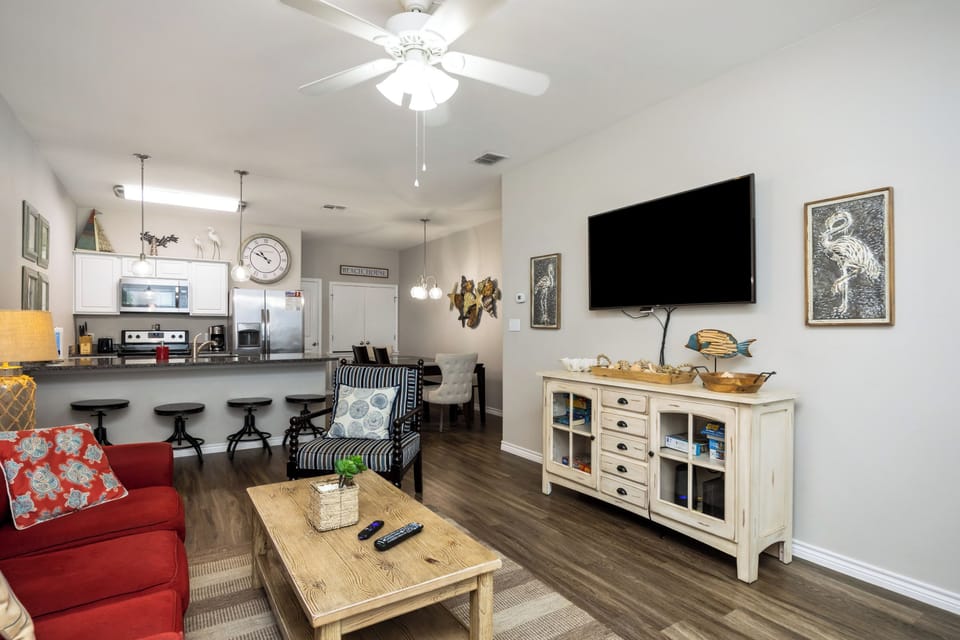 Unwind in your cozy living space with comfortable seating, modern TV, and open kitchen perfect for preparing meals.
