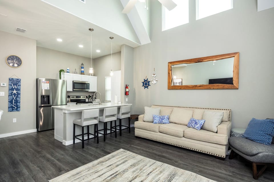 Relax in your bright, open-concept living space with soaring ceilings, modern kitchen, and coastal touches throughout.