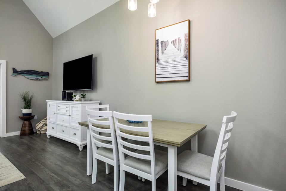 Your bright dining space features coastal charm with a spacious table for meals and a flatscreen TV for entertainment during downtime.