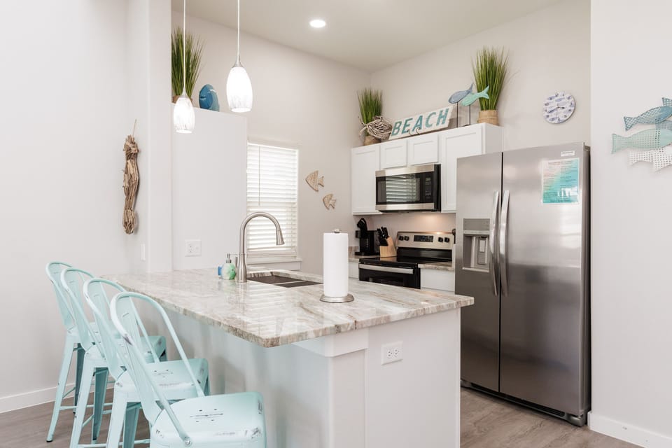 Your bright coastal kitchen invites you to whip up delicious meals with ocean-themed charm and modern conveniences at your fingertips.