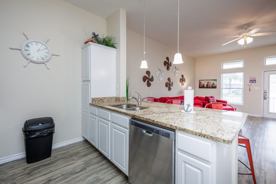 Your fully equipped kitchen features granite countertops, modern appliances, and pendant lighting, perfect for preparing meals together.