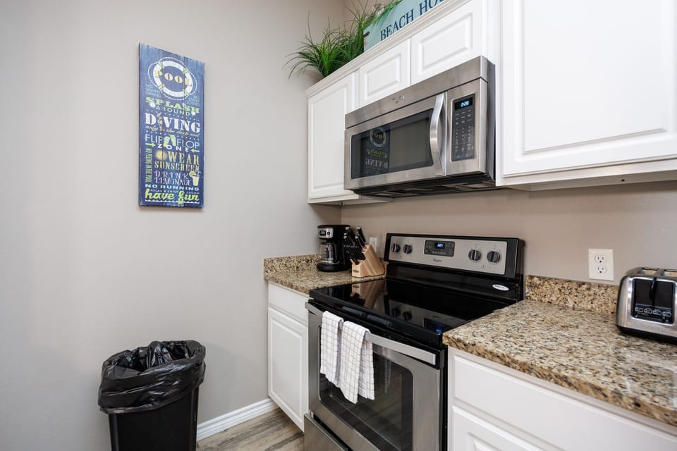 Your fully equipped kitchen features granite counters, stainless appliances, and cheerful beach decor—everything you need to prepare delicious meals during your stay.