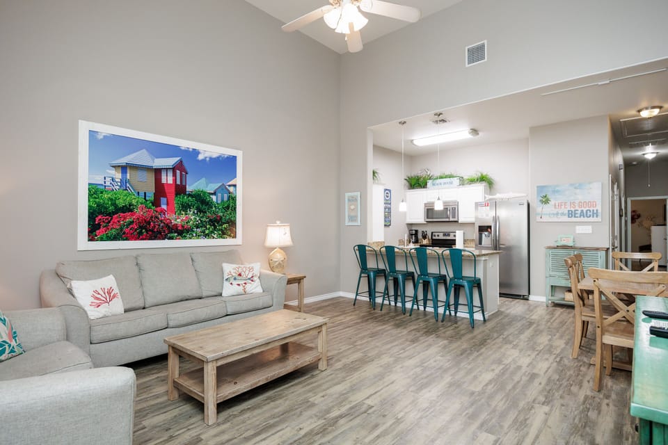 Relax in your bright, open living space where coastal charm meets modern comfort with beach-themed decor and a fully equipped kitchen.