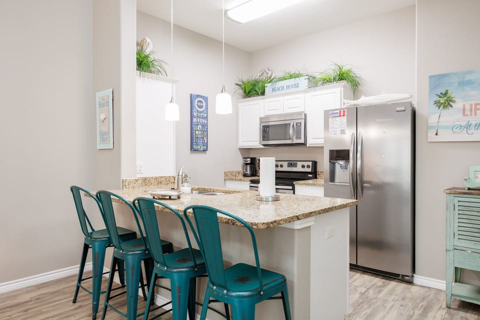 Your fully equipped kitchen features granite countertops, stainless steel appliances, and cheerful coastal décor that makes cooking feel like a beach vacation.