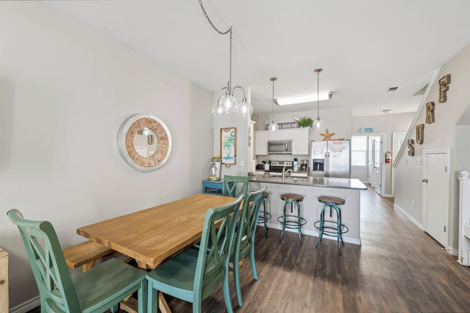 Gather around the inviting dining table or pull up a seat at the kitchen island—your home base for meals, morning coffee, and vacation planning together.