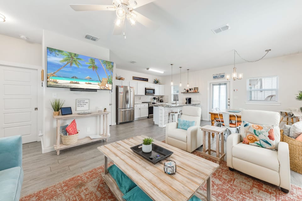 Relax in your bright, open living space where coastal charm meets modern comfort with a fully equipped kitchen and cozy seating.