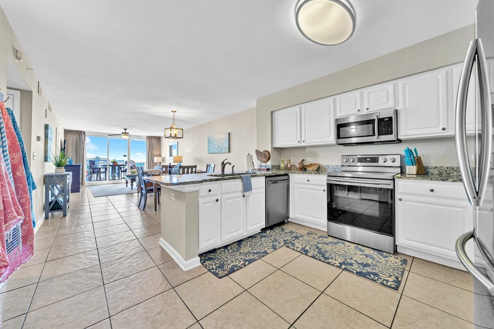 Your spacious kitchen flows into the living area, featuring granite counters, stainless appliances, and everything you need to prepare meals together.