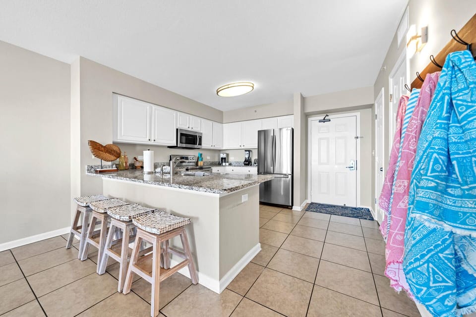Your modern kitchen awaits with granite counters, full appliances, and a breakfast bar perfect for casual meals and morning coffee.