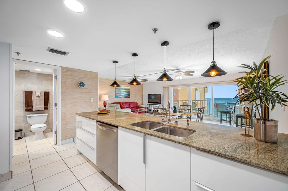 Modern kitchen. Granite counter top. Island wrapped around with glass tiles. 
