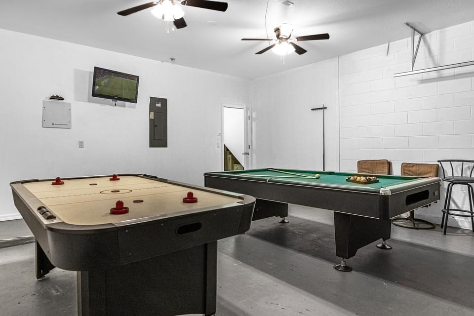 Game room in the garage with a TV, fans, and plenty of chairs!
