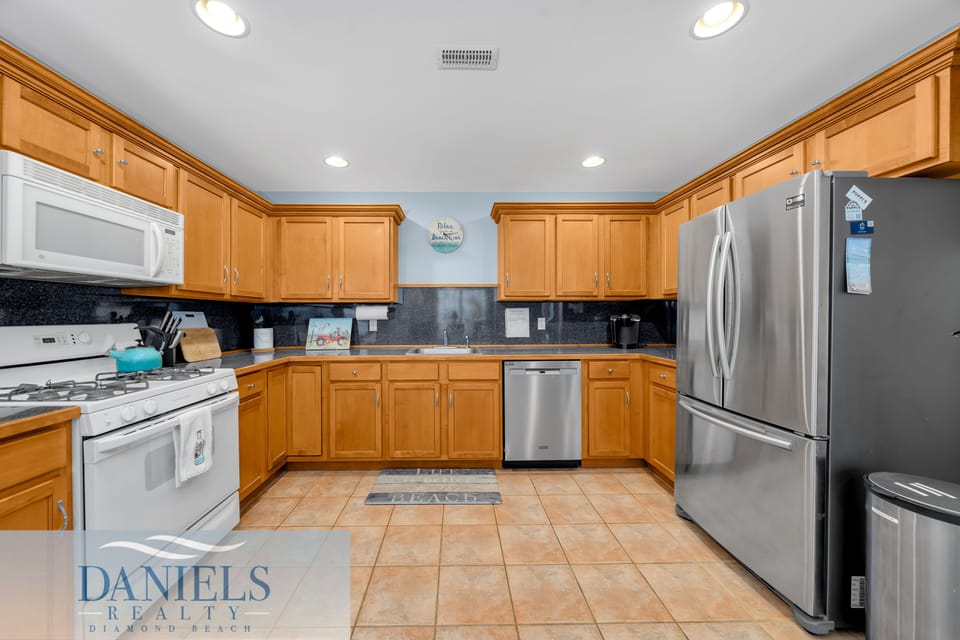 Open kitchen, stainless steel appliances, plenty of counter space.