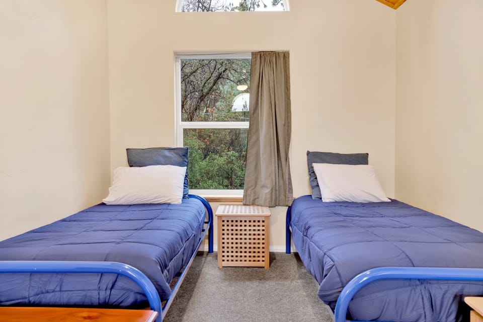 Peaceful cabin bedroom with plush bedding, and beautiful views—ideal for restful nights, cozy mornings, and a relaxing mountain escape.