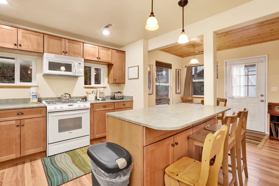 Fully equipped cabin kitchen with ample cabinetry, stove, fridge, microwave, and coffee maker—perfect for cooking meals, morning coffee, and feeling right at home on your stay.