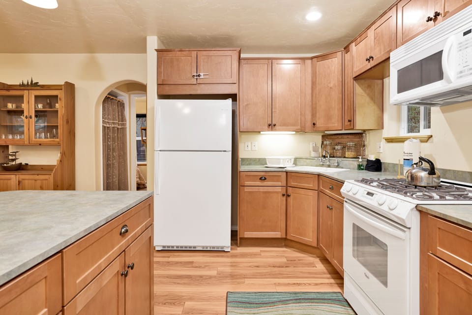 Fully equipped cabin kitchen with ample cabinetry, stove, fridge, microwave, and coffee maker—perfect for cooking meals, morning coffee, and feeling right at home on your stay.