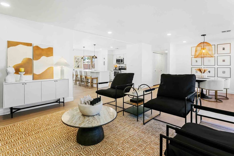 Formal living room with comfortable seating, marble side tables and coffee table, games, and 74" electric fireplace