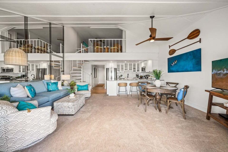 Beautifully updated open living space featuring a lofted ceiling, dining area, and ocean‑view lounge