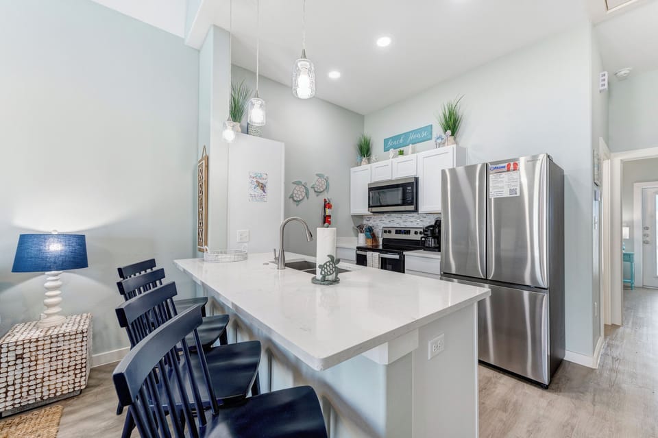 Your modern kitchen features stainless steel appliances, quartz countertops, and pendant lighting perfect for cooking memorable vacation meals together.