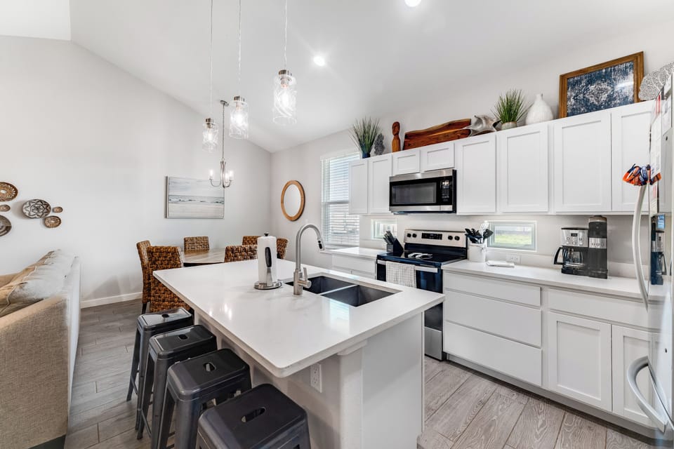 Your modern kitchen features white cabinets, quartz countertops, and full appliances perfect for preparing meals during your stay.